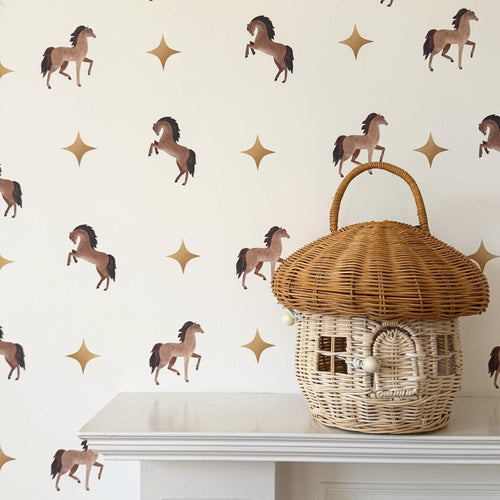 Wicker basket with a lid on a surface against a wall with horse and star pattern